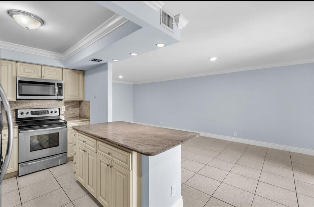 1321 Partridge Close, Unit 60 Pompano Beach, FL 33064 - Photo 11 of 28 a kitchen with granite countertop a stove sink and microwave