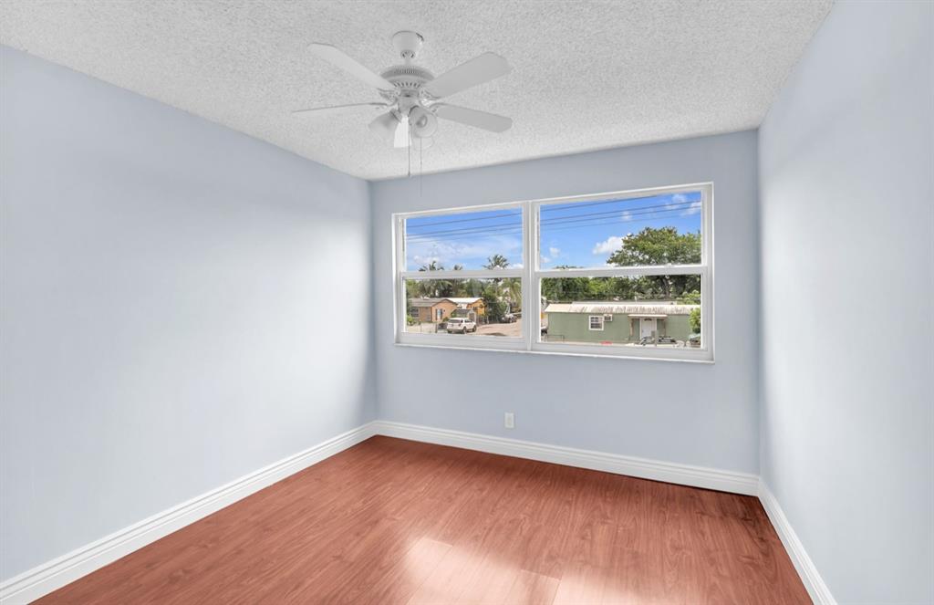 1321 Partridge Close, Unit 60 Pompano Beach, FL 33064 - Photo 18 of 28 a view of an empty room with wooden floor and a window