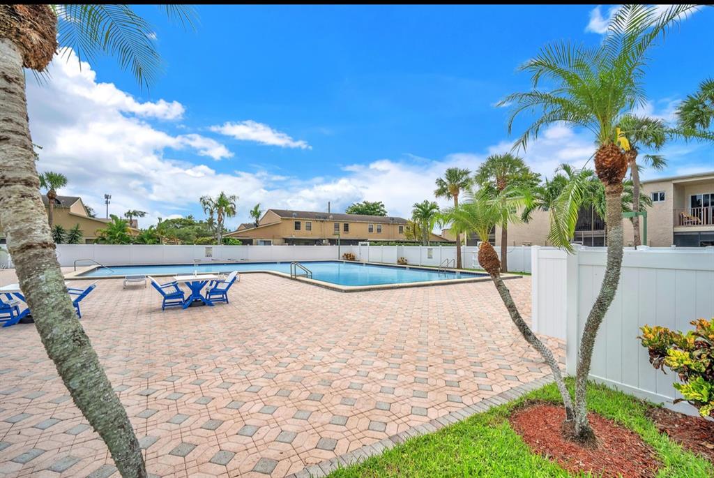 1321 Partridge Close, Unit 60 Pompano Beach, FL 33064 - Photo 27 of 28 a view of a swimming pool with a lawn chairs