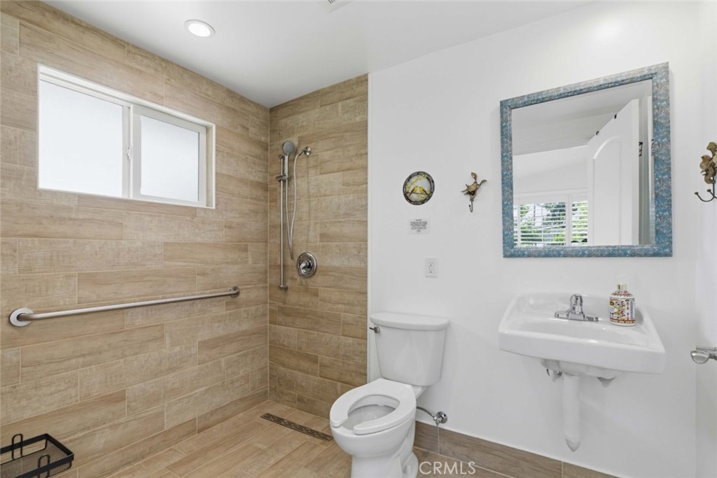301 West Ashby Street Azusa, CA 91702 - Photo 61 of 75 a bathroom with a toilet a sink and mirror