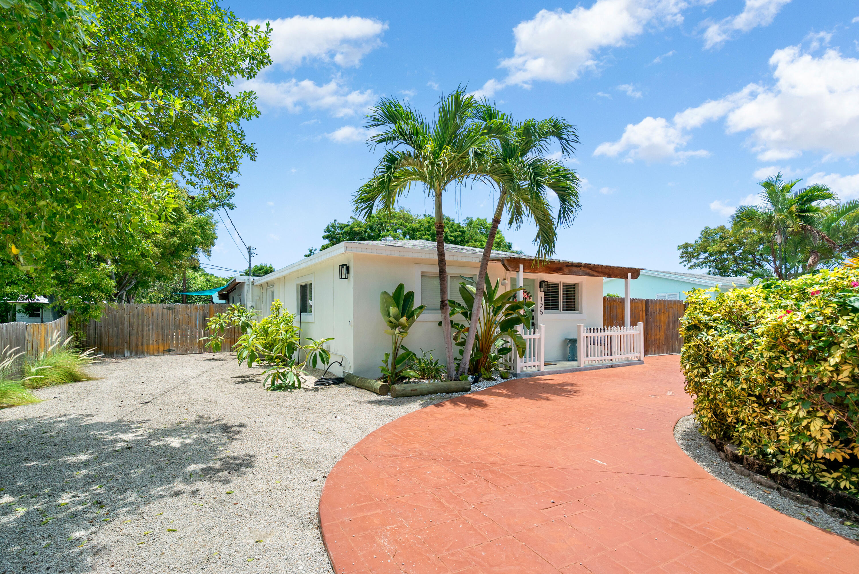 a front view of a house with a yard and potted plants