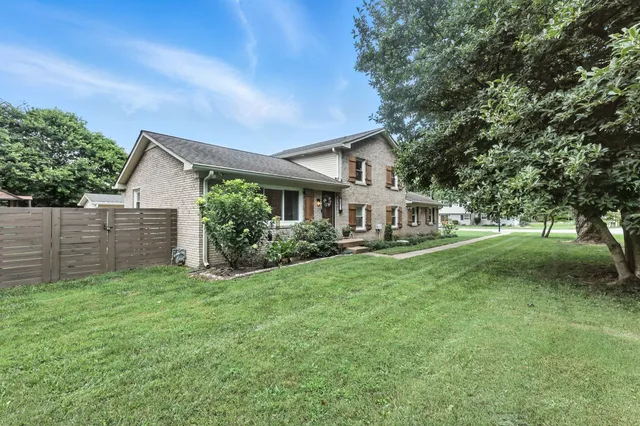 a front view of a house with yard and green space