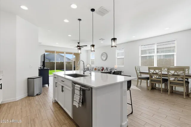 a kitchen with stainless steel appliances granite countertop a sink a stove and a wooden floor