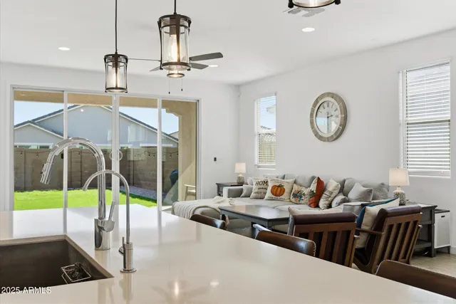 a living room with furniture a flat screen tv and a floor to ceiling window