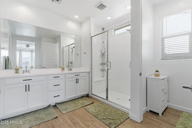 a spacious bathroom with a shower sink and mirror