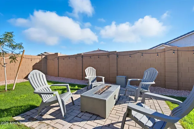 a view of a chairs and table in the back yard of the house