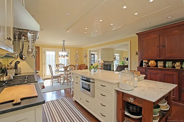 a large kitchen with kitchen island a large counter space a sink appliances and cabinets