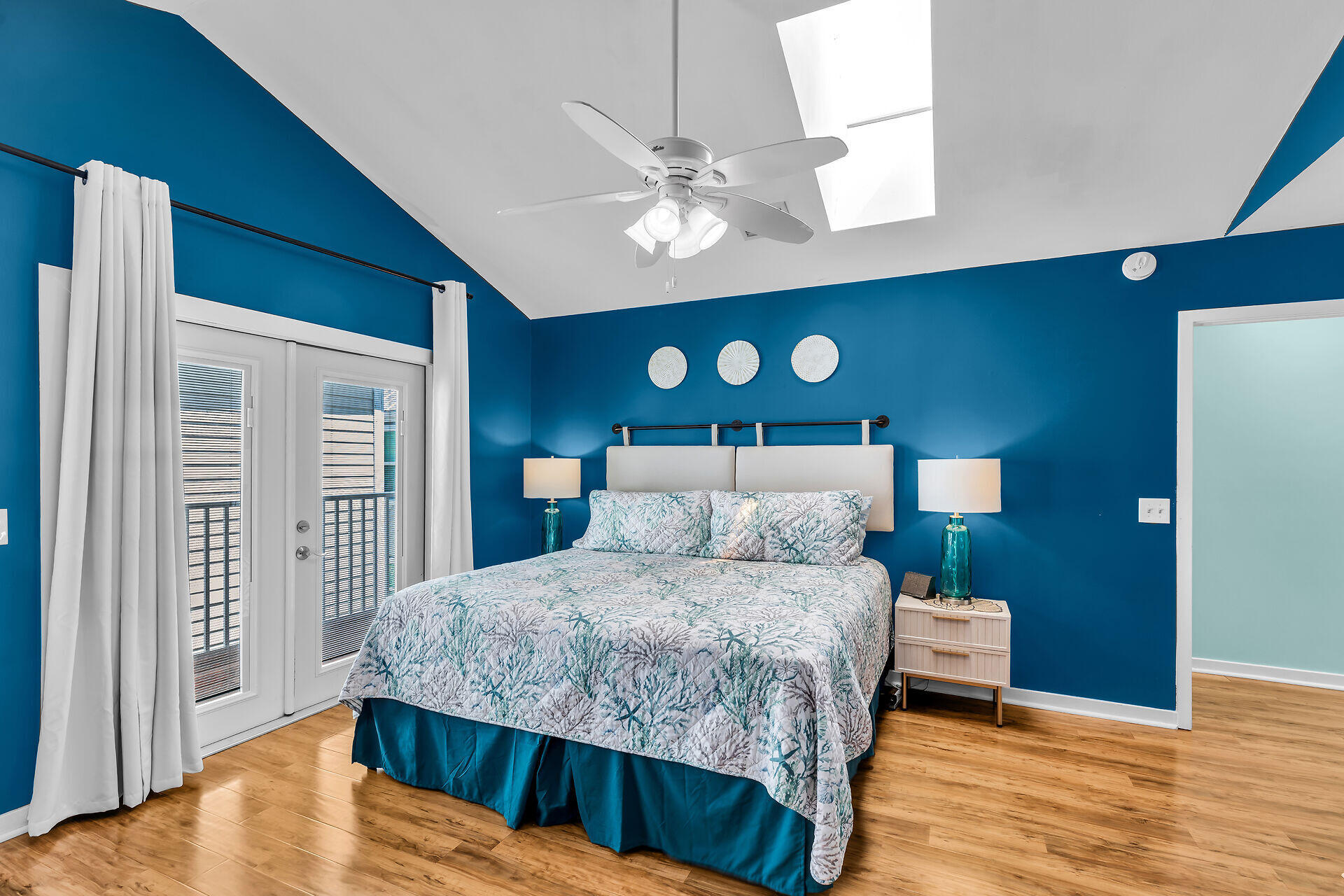 a bedroom with a large bed a chandelier and a dresser