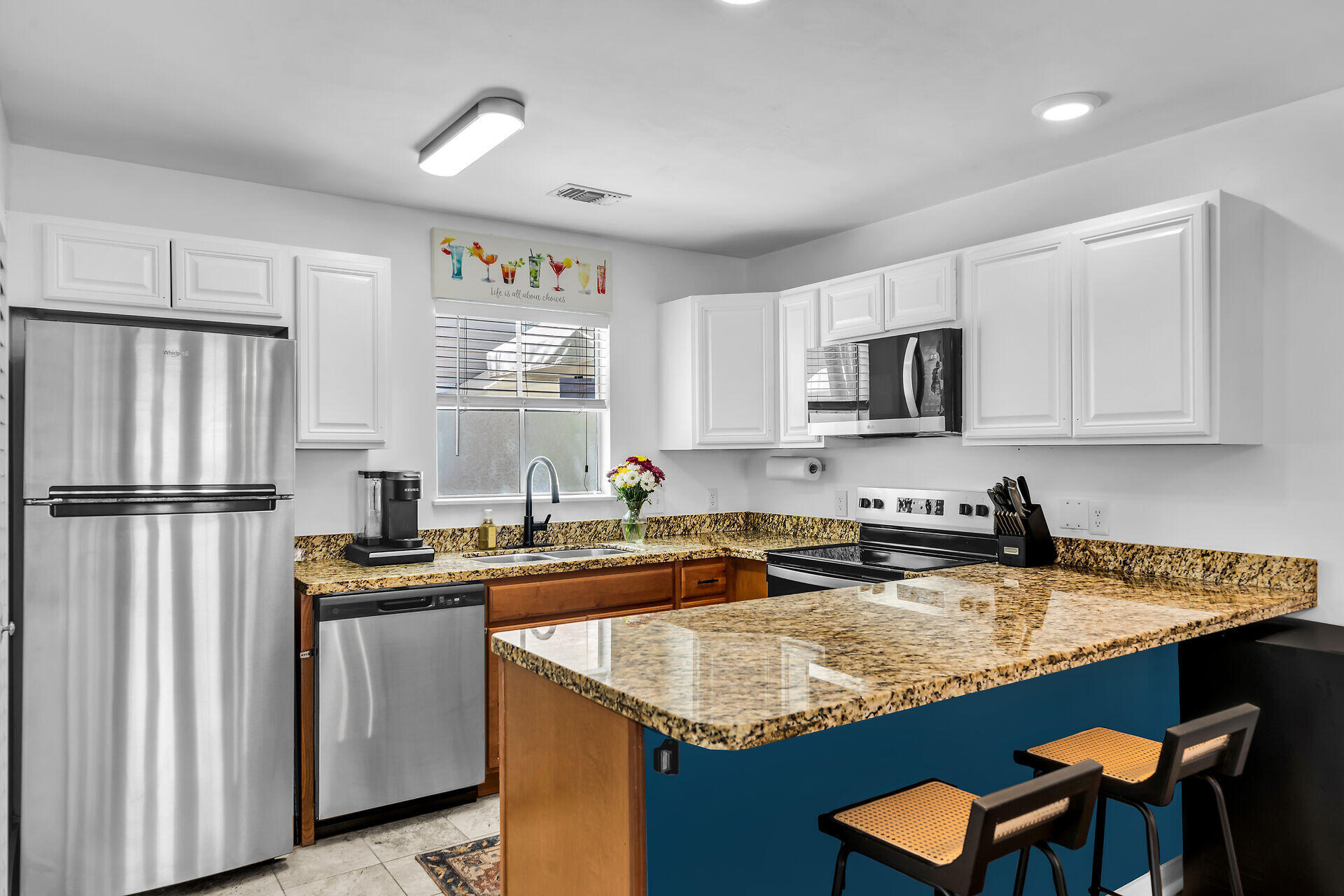 1075 Duval Street, Unit R10 Key West, FL 33040 - Photo 14 of 38 a kitchen with stainless steel appliances granite countertop a sink stove and refrigerator