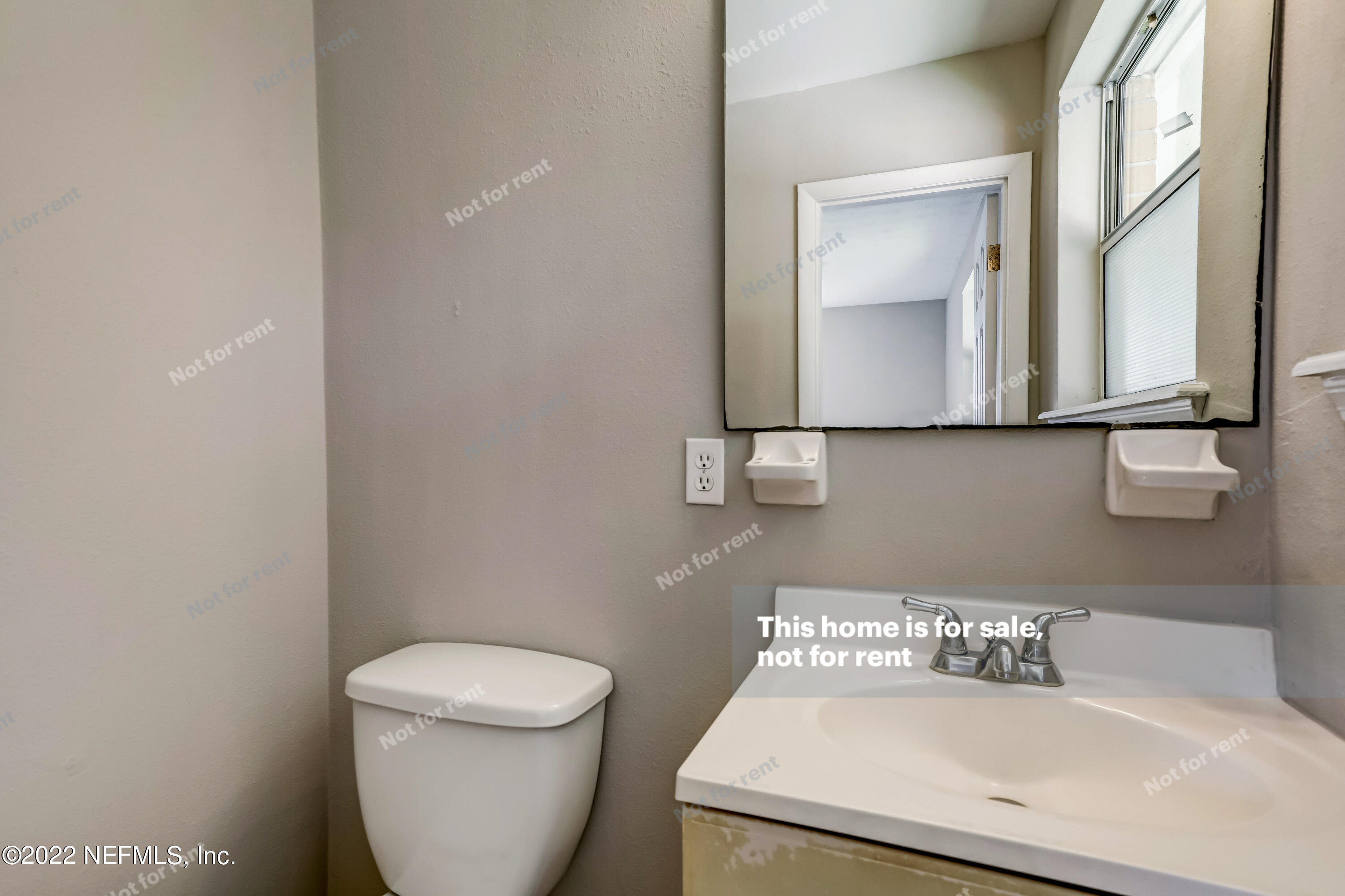 7403 Sandhurst Road South Jacksonville, FL 32277 - Photo 21 of 29 a bathroom with a toilet a sink and mirror