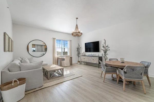 a living room with furniture a flat screen tv and a window
