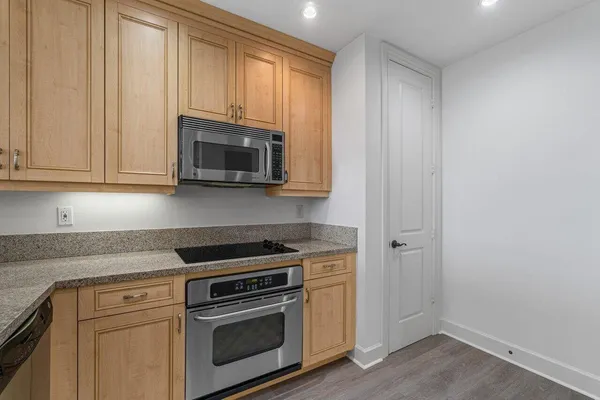 a kitchen with granite countertop white cabinets and stainless steel appliances