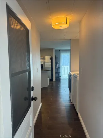 a view of a hallway with wooden floor and a bathroom