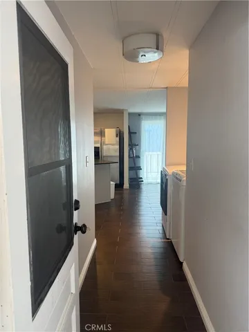 a view of a hallway with wooden floor windows and a livingroom