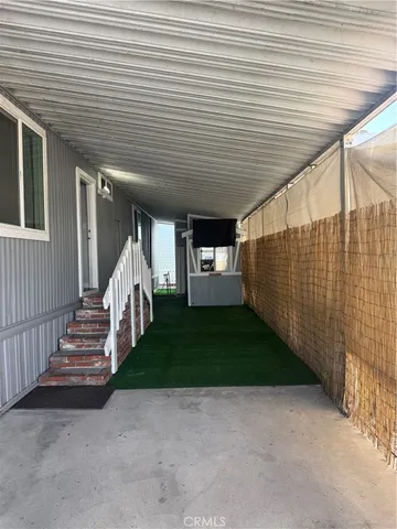 a view of a patio with table and chairs and a barbeque