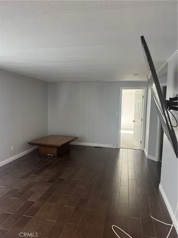 an empty room with wooden floor and entrance