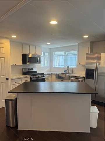 a modern kitchen with stainless steel appliances granite countertop a sink a stove and a refrigerator