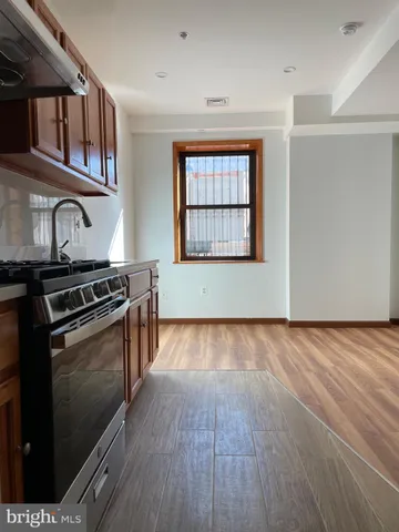 a view of a kitchen with stainless steel appliances wooden floor and a window