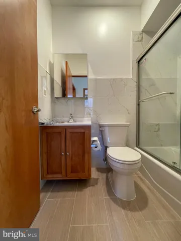 a bathroom with a toilet a sink and mirror