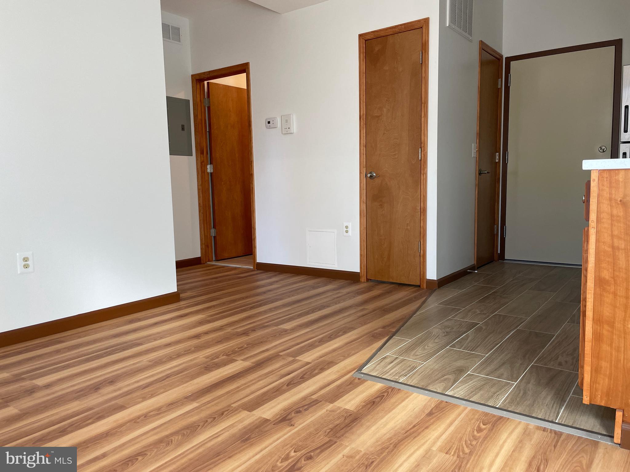 146 North 10th Street, Unit 3C Philadelphia, PA 19107 - Photo 13 of 14 a view of an empty room with wooden floor and a window