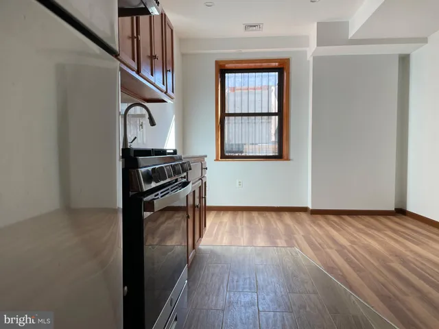 a view of a hallway with wooden floor and a window