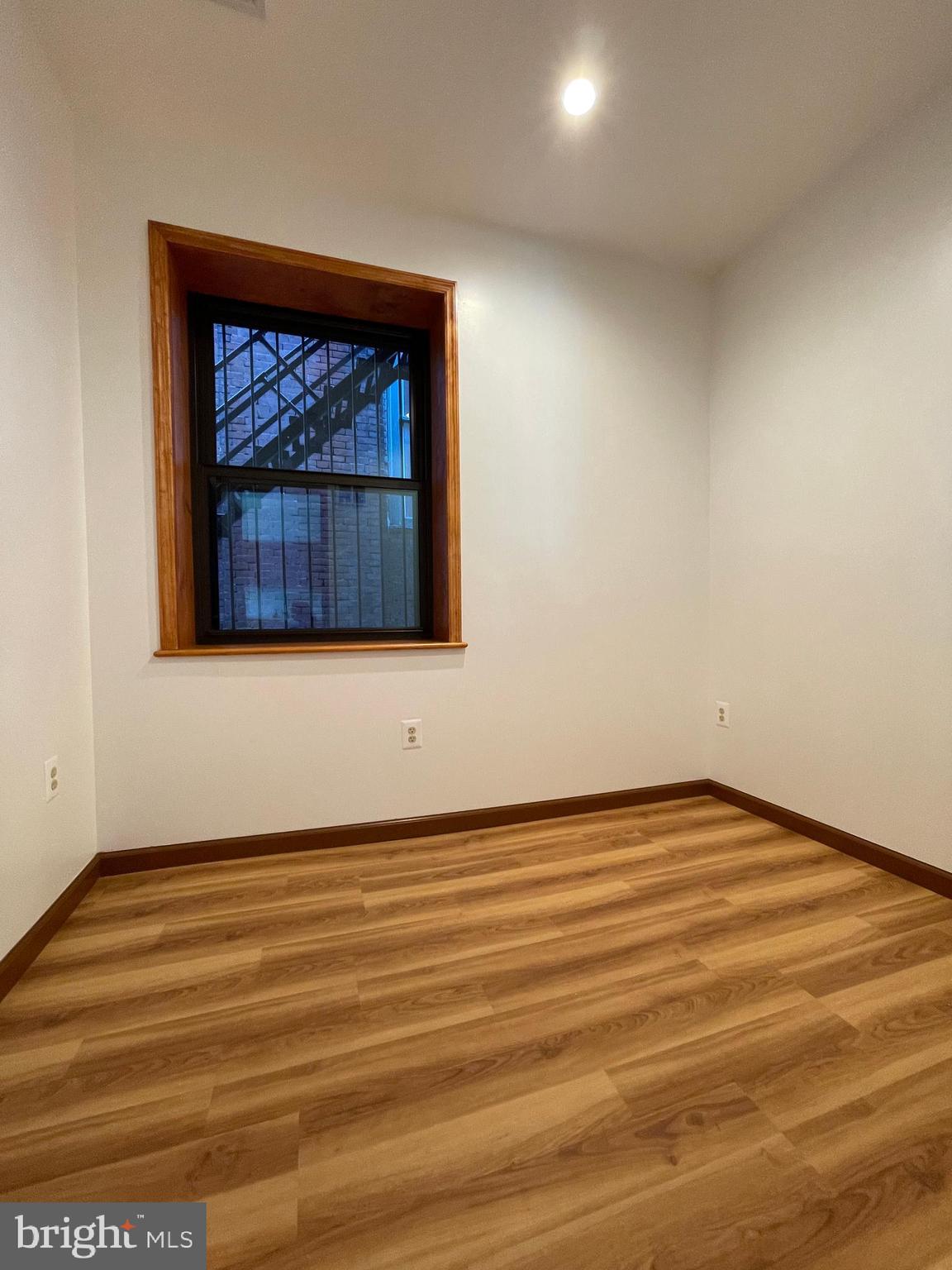 146 North 10th Street, Unit 3C Philadelphia, PA 19107 - Photo 8 of 14 a view of an empty room with wooden floor and a window