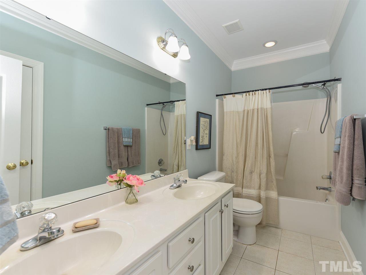 6005 Maton Place Raleigh, NC 27603 - Photo 17 of 30 a bathroom with a double vanity sink toilet mirror and shower