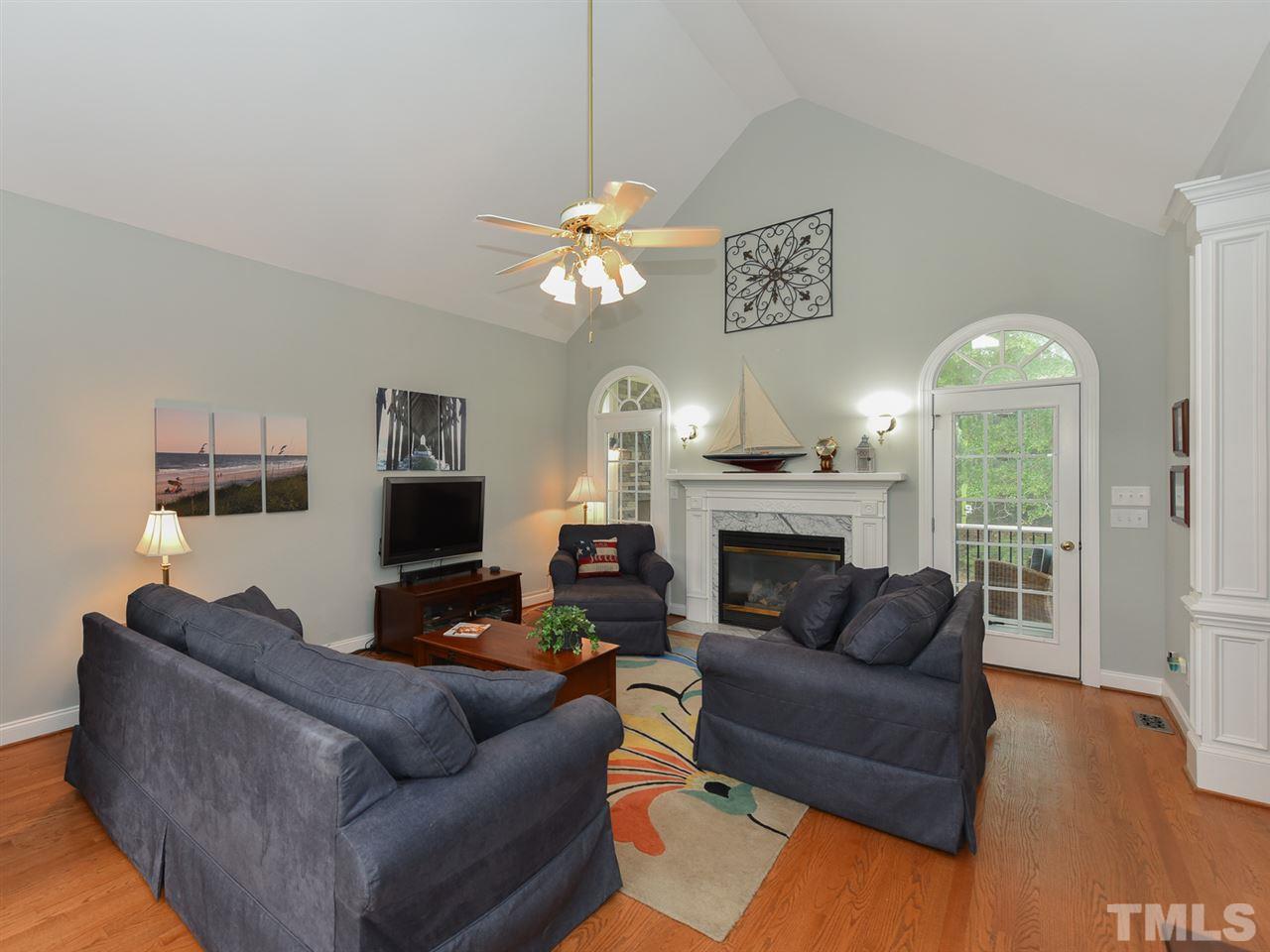 6005 Maton Place Raleigh, NC 27603 - Photo 4 of 30 a living room with furniture a fireplace and a chandelier