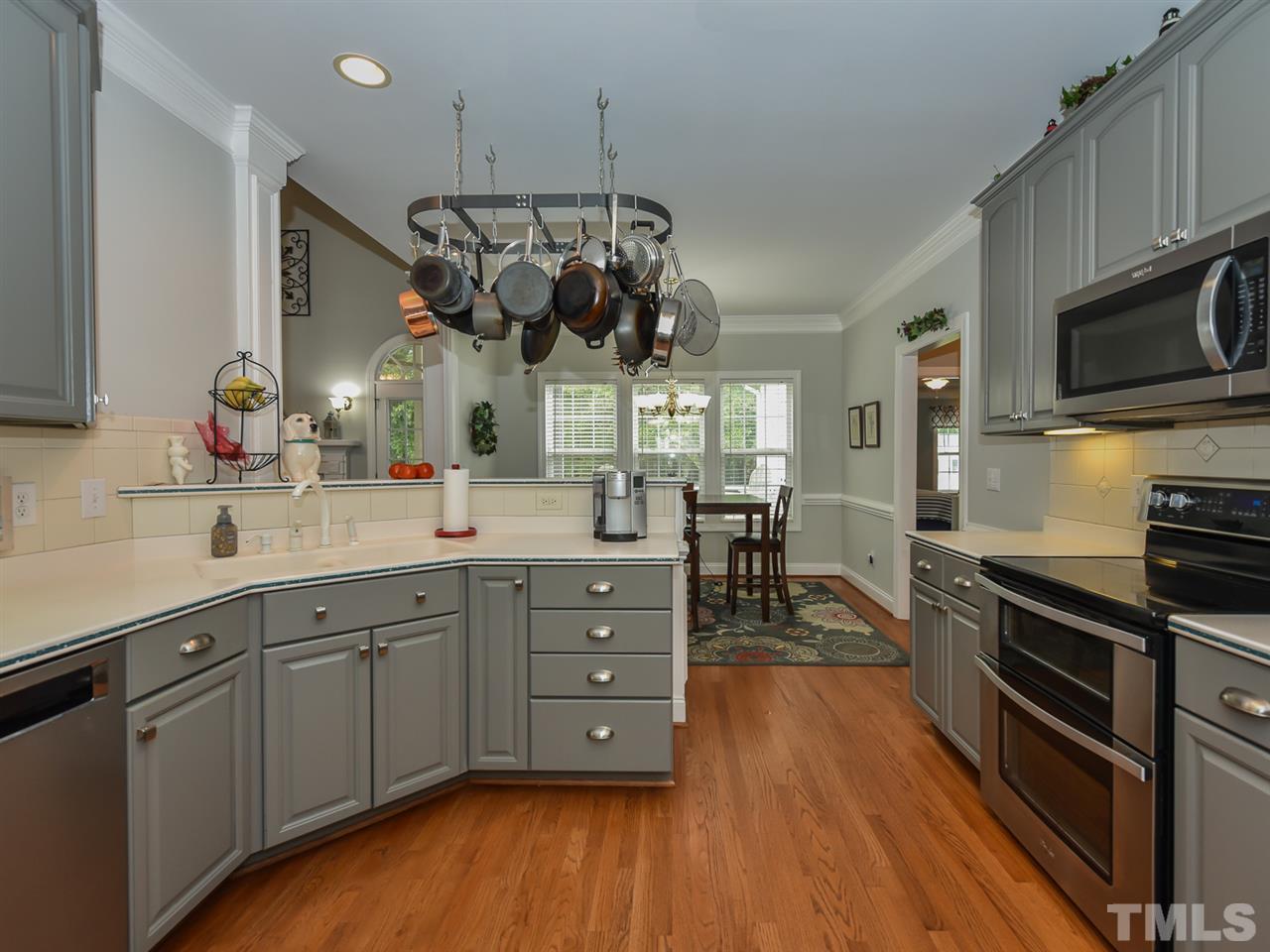 6005 Maton Place Raleigh, NC 27603 - Photo 7 of 30 a kitchen with stainless steel appliances granite countertop wooden floors and granite counter tops