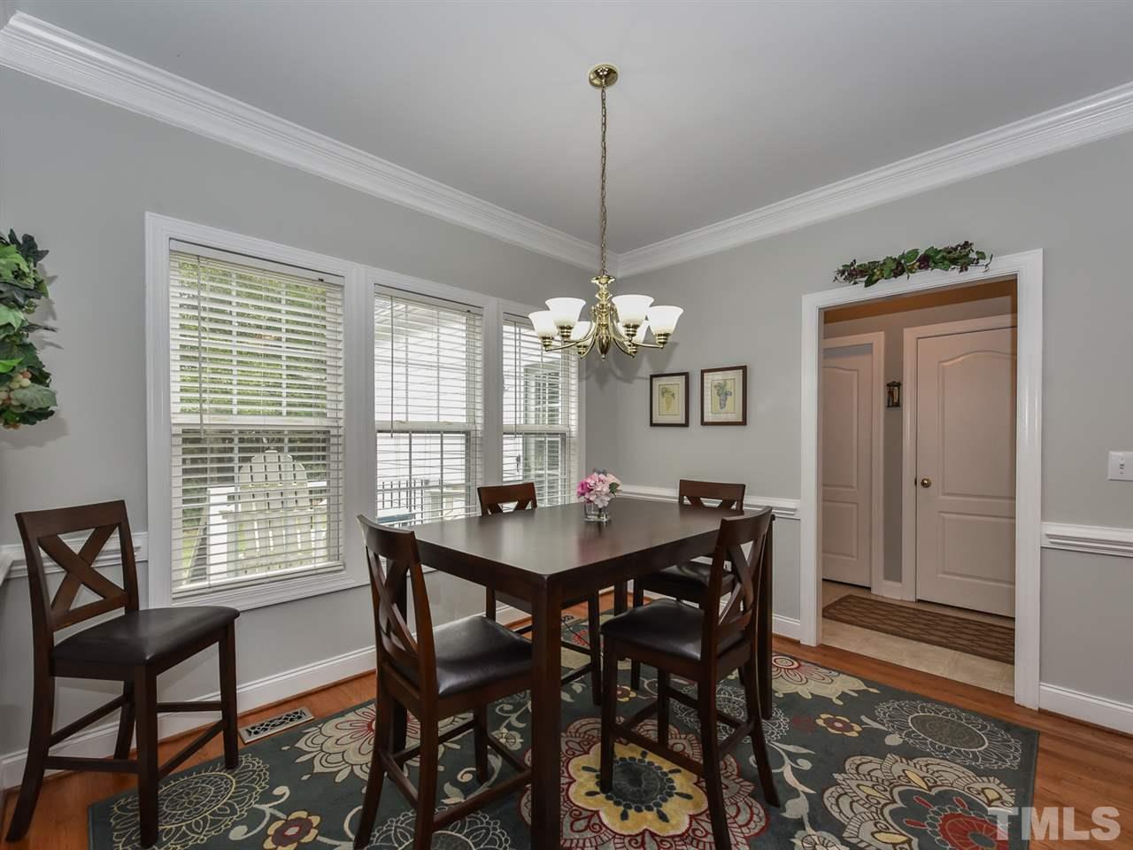 6005 Maton Place Raleigh, NC 27603 - Photo 10 of 30 a view of a dining room with furniture a chandelier and wooden floor