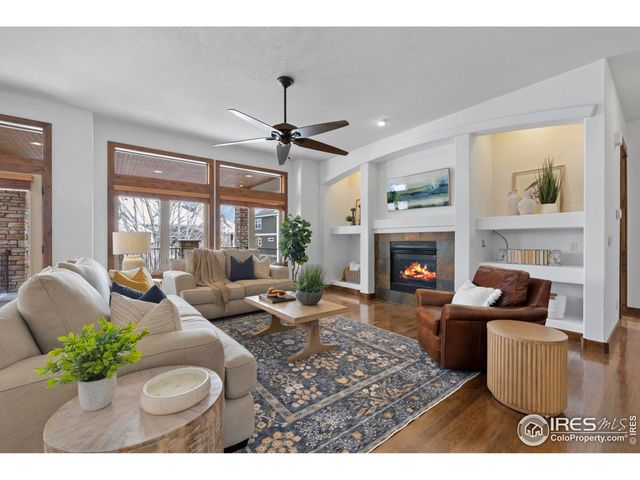 a living room with furniture a large window and a fireplace