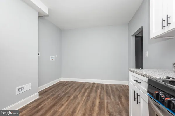 a kitchen with a stove and a wooden floor
