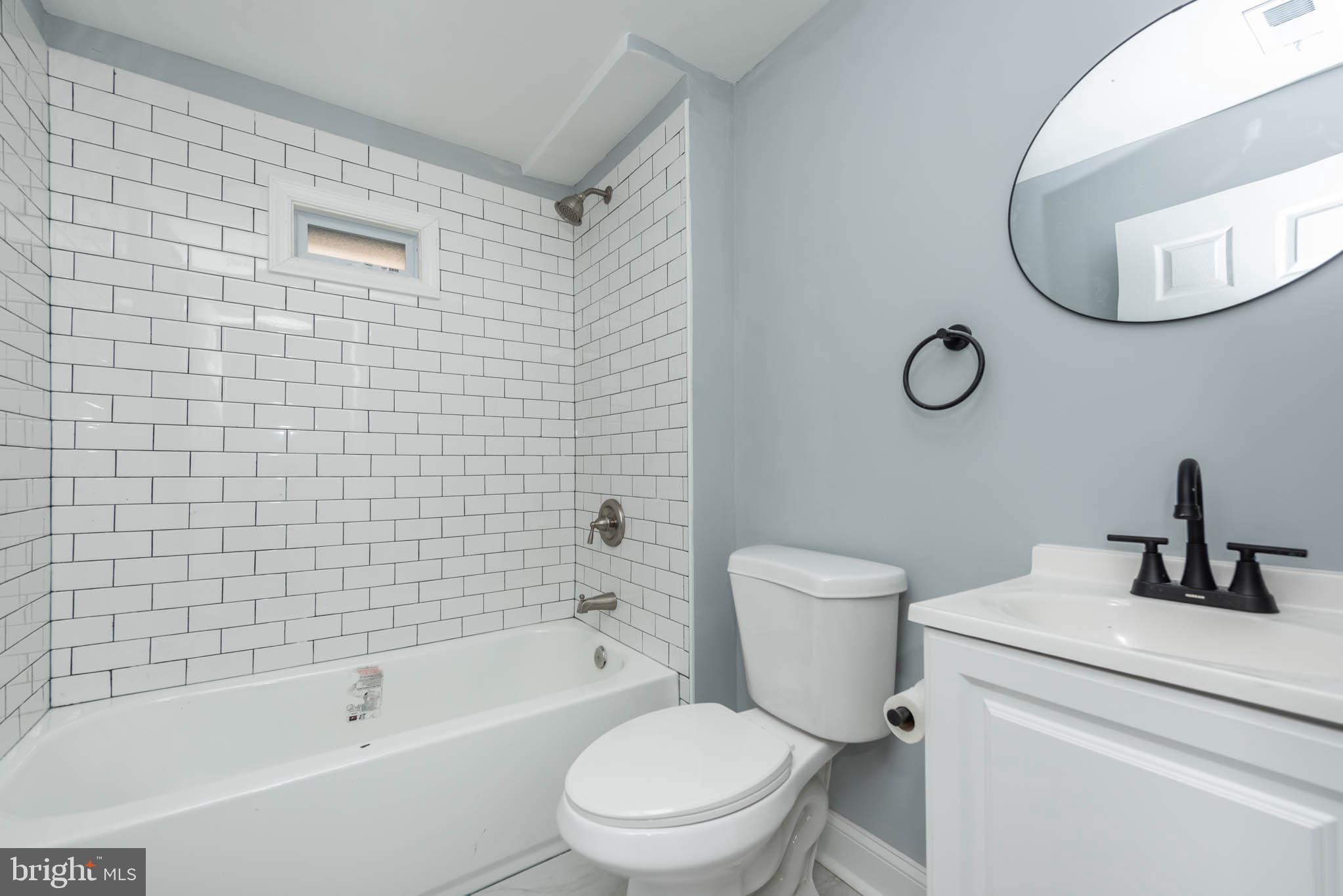 1909 Harlem Avenue Baltimore, MD 21217 - Photo 16 of 27 a bathroom with a toilet a sink a mirror and bathtub