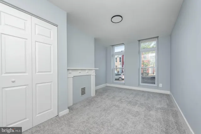 an empty room with windows and closet