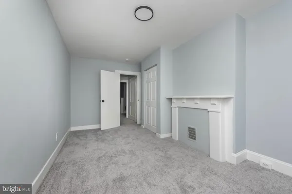 an empty room with a fireplace and painted walls