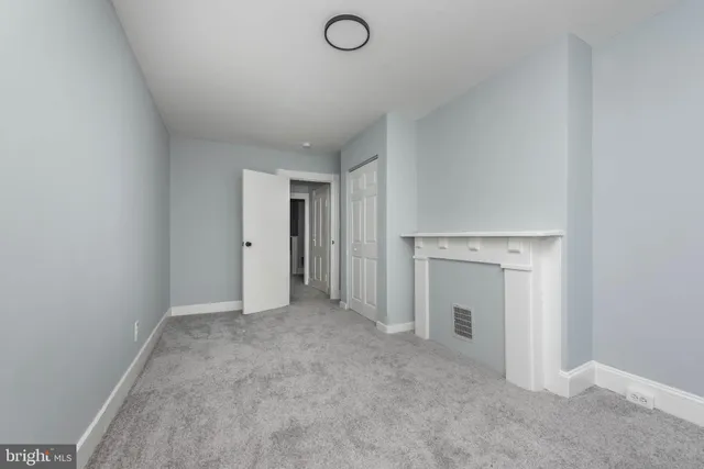 an empty room with a fireplace and painted walls