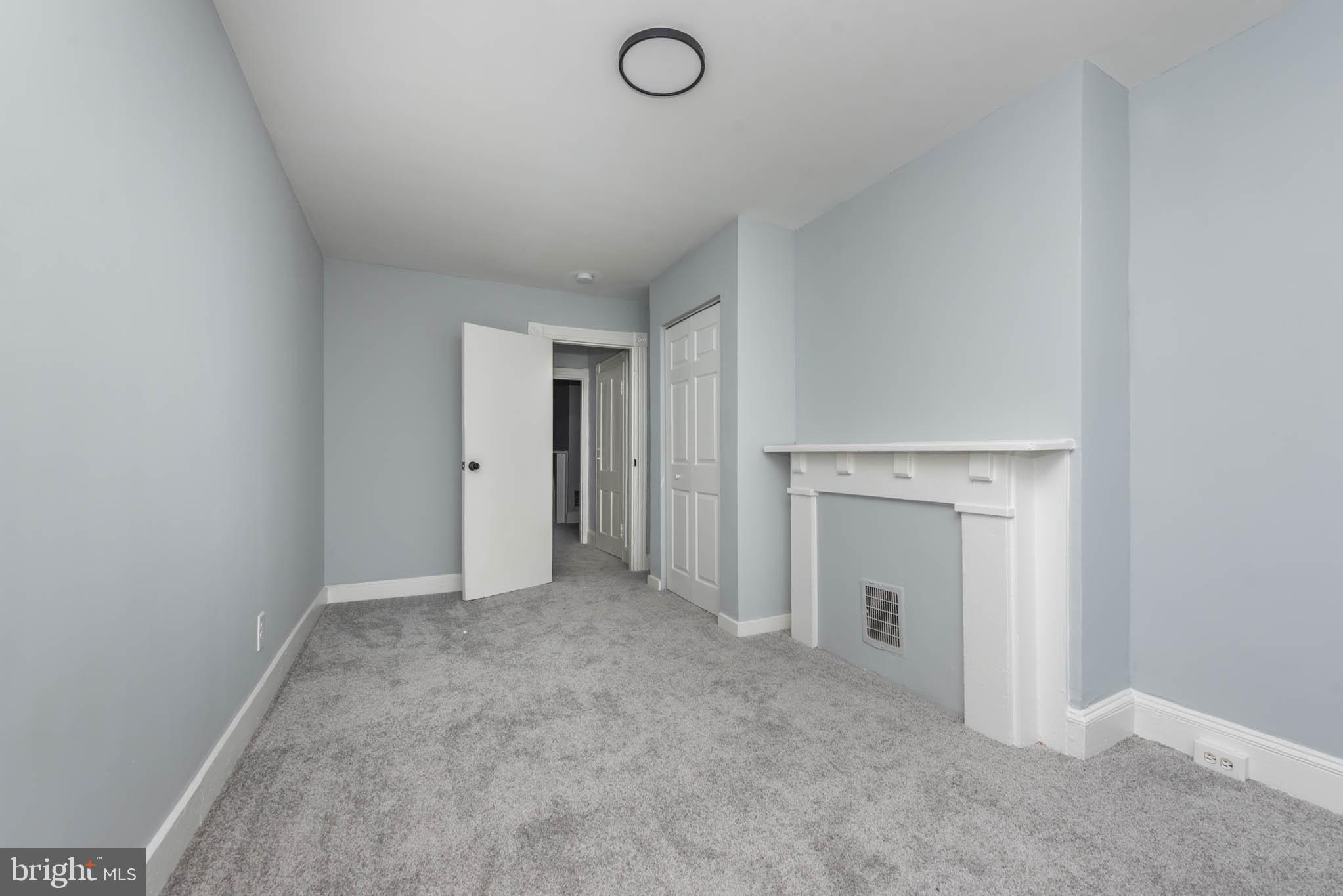 1909 Harlem Avenue Baltimore, MD 21217 - Photo 3 of 27 an empty room with a fireplace and painted walls