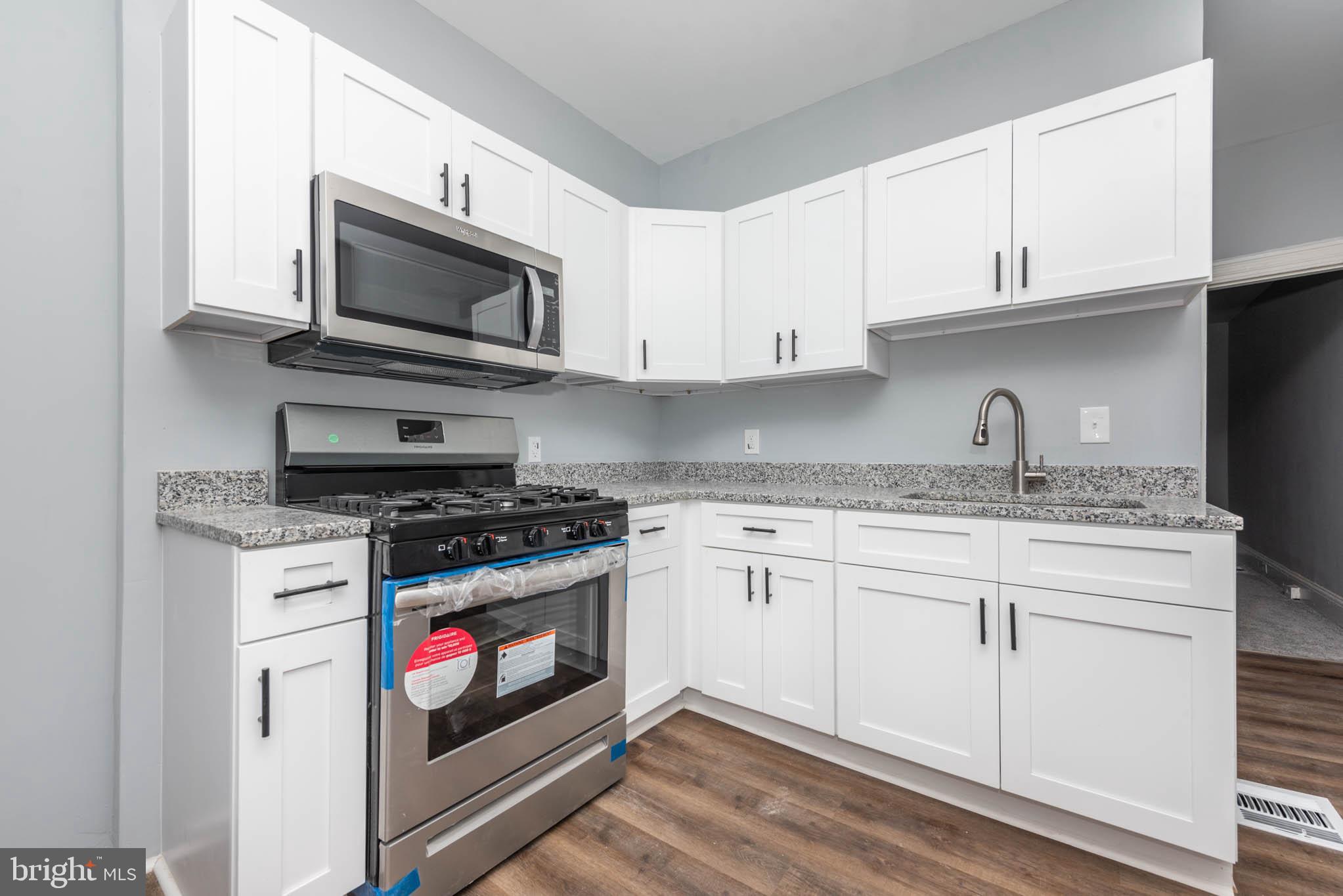 1909 Harlem Avenue Baltimore, MD 21217 - Photo 8 of 27 a kitchen with granite countertop white cabinets stainless steel appliances and a sink