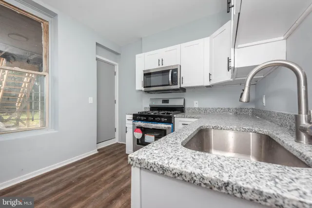 a kitchen with a sink cabinets and a wooden floor