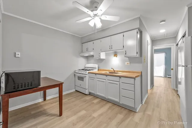 a kitchen with sink cabinets and wooden floor