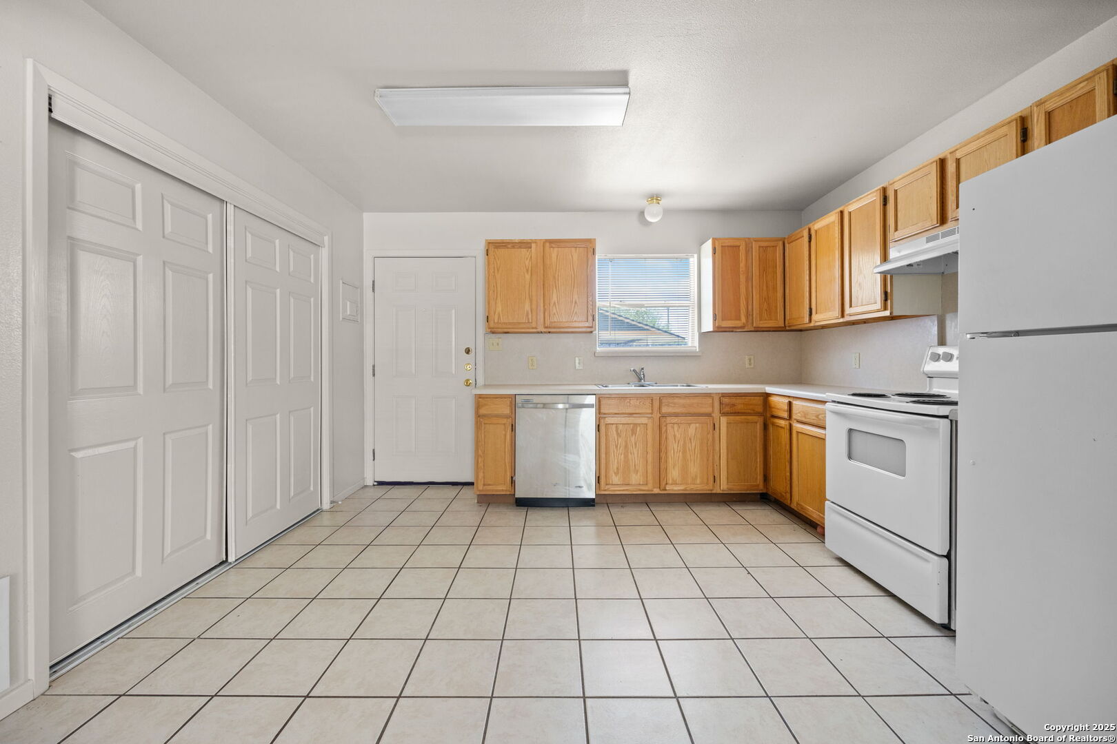 1118 West Goodwin Street, Unit C Pleasanton, TX 78064 - Photo 4 of 13 a kitchen with a stove a sink and a refrigerator