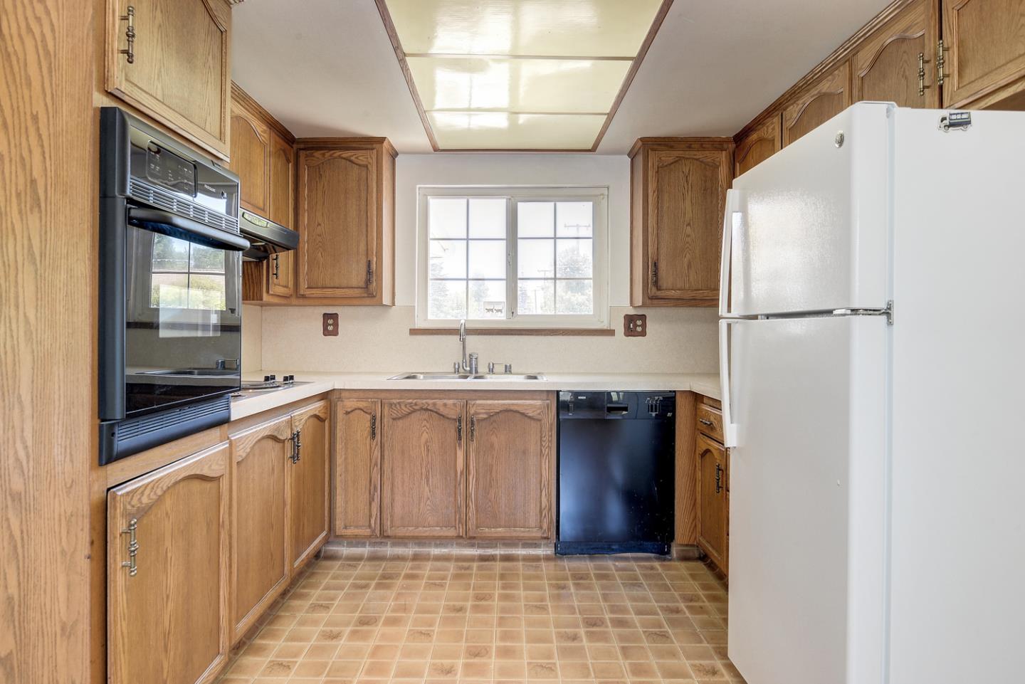 20631 McClellan Road Cupertino, CA 95014 - Photo 5 of 26 a kitchen with a refrigerator a sink and cabinets