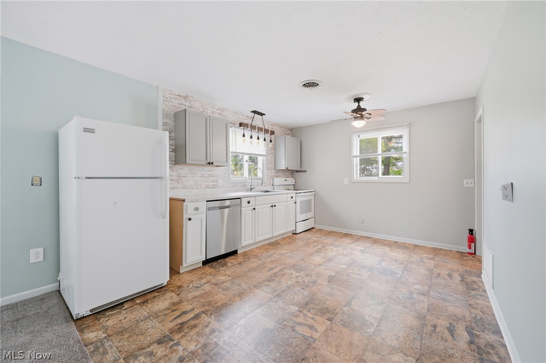 4570 Pymatuning Lake Road Andover, OH 44003 - Photo 17 of 38 Kitchen area featuring wood-finish flooring, light gray cabinetry, a stainless steel dishwasher, a white refrigerator, and a white electric range