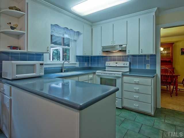 113 Bayleaf Drive Raleigh, NC 27615 - Photo 7 of 23 Kitchen with corian countertops, tile floor and picture window over sink.