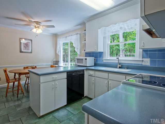 113 Bayleaf Drive Raleigh, NC 27615 - Photo 8 of 23 Kitchen opens to breakfast room overlooking wood deck