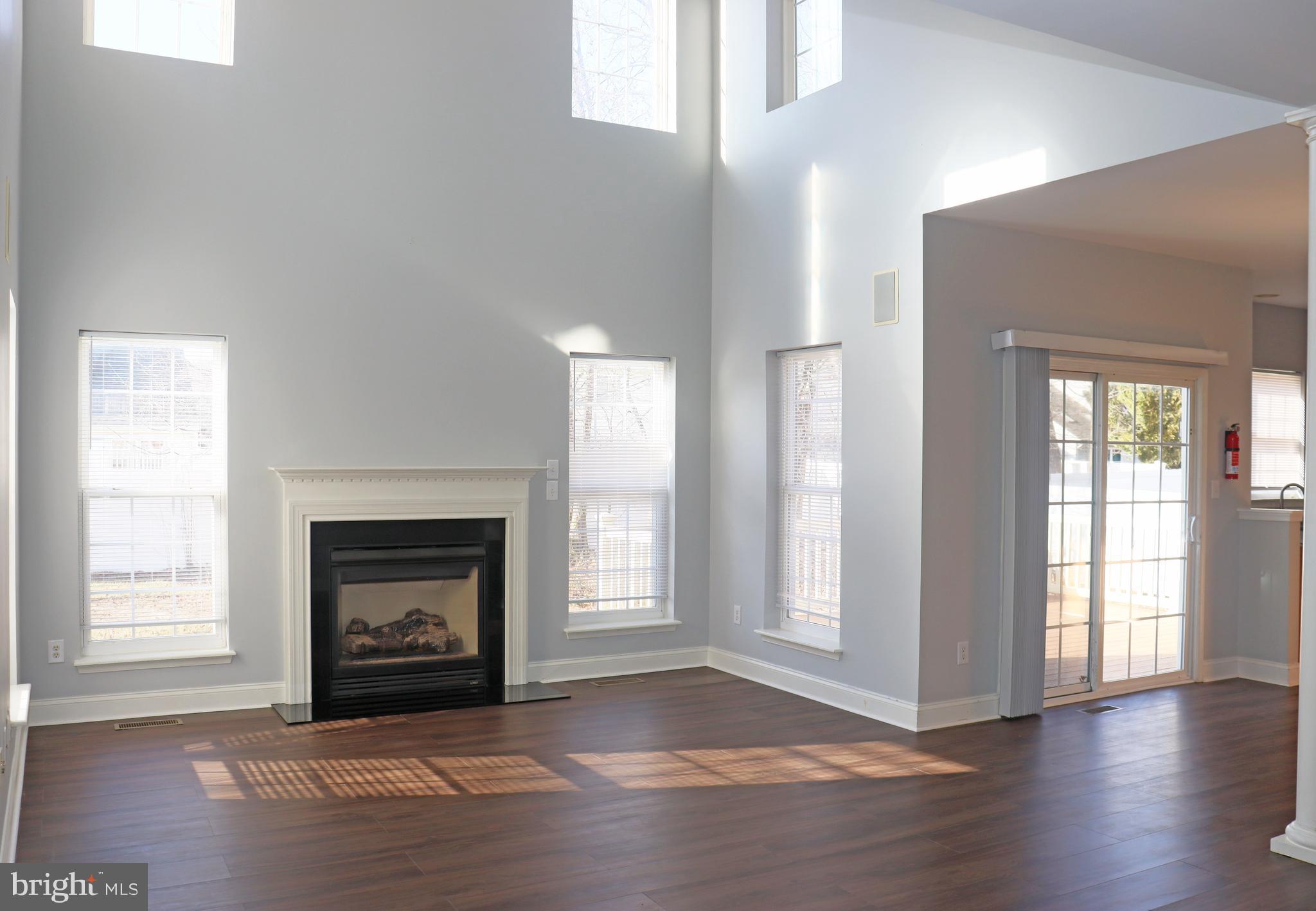 24 Blue Spruce Drive Bear, DE 19701 - Photo 6 of 13 a view of an empty room with wooden floor fireplace and a window