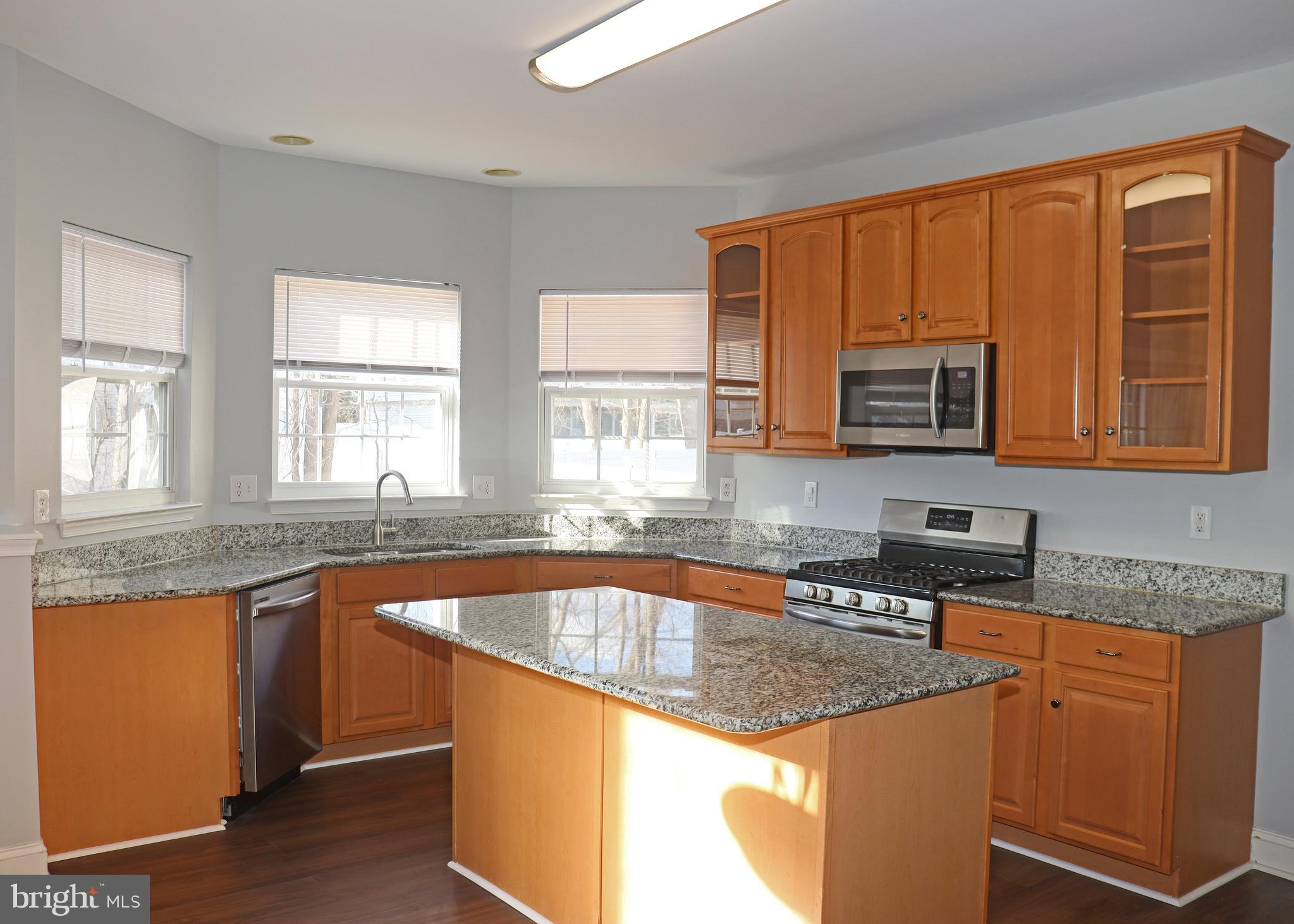 24 Blue Spruce Drive Bear, DE 19701 - Photo 8 of 13 a kitchen with stainless steel appliances granite countertop a sink stove and microwave