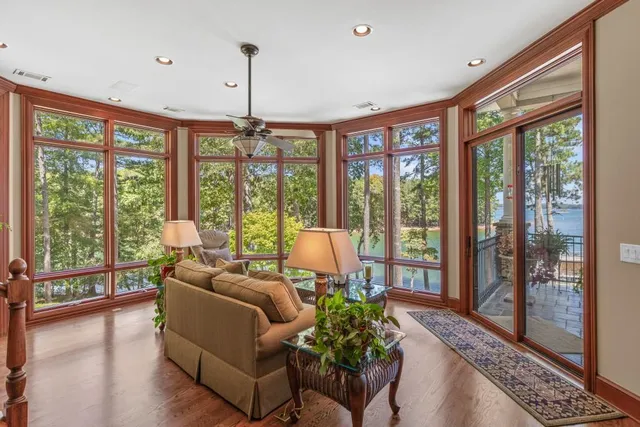 a living room with furniture a ceiling fan and a large window