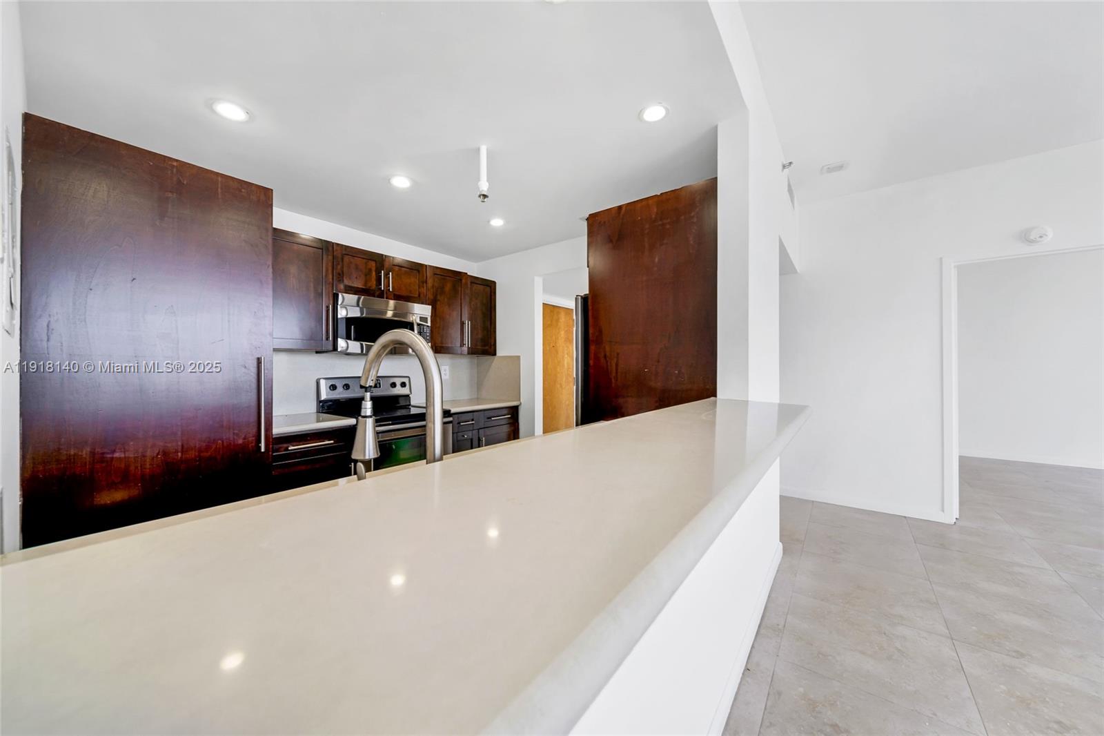 7601 East Treasure Drive, Unit PH215 North Bay Village, FL 33141 - Photo 17 of 40 a large white kitchen with wooden floor and a refrigerator