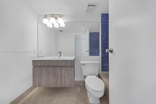 a bathroom with a toilet a sink and mirror